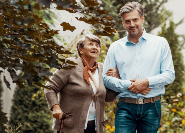 Man and older lady walking in garden