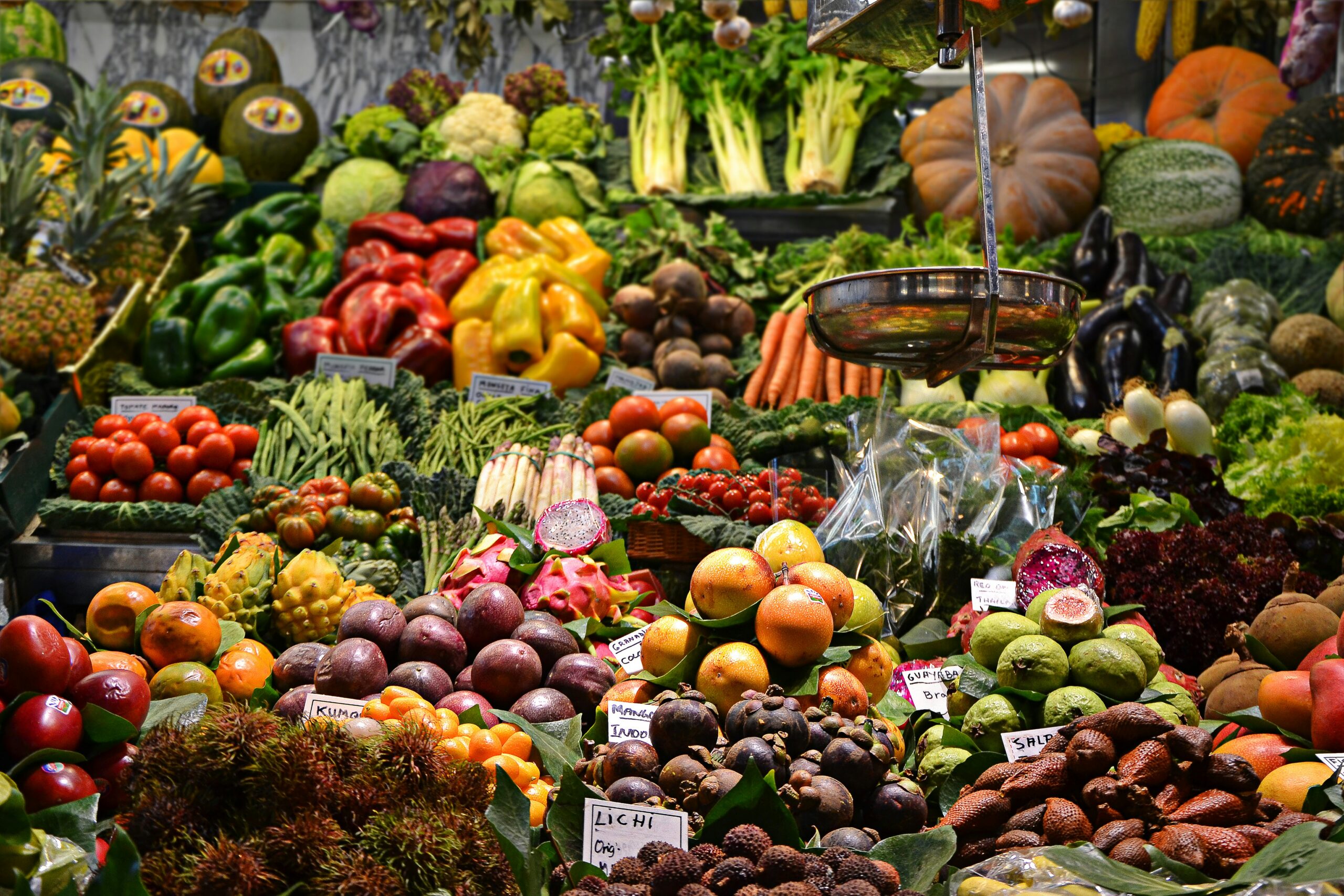 Colorful display of fresh fruit and vegetables at a market in Louth, featuring a variety of seasonal produce, including apples, carrots, and leafy greens, under a bright canopy.