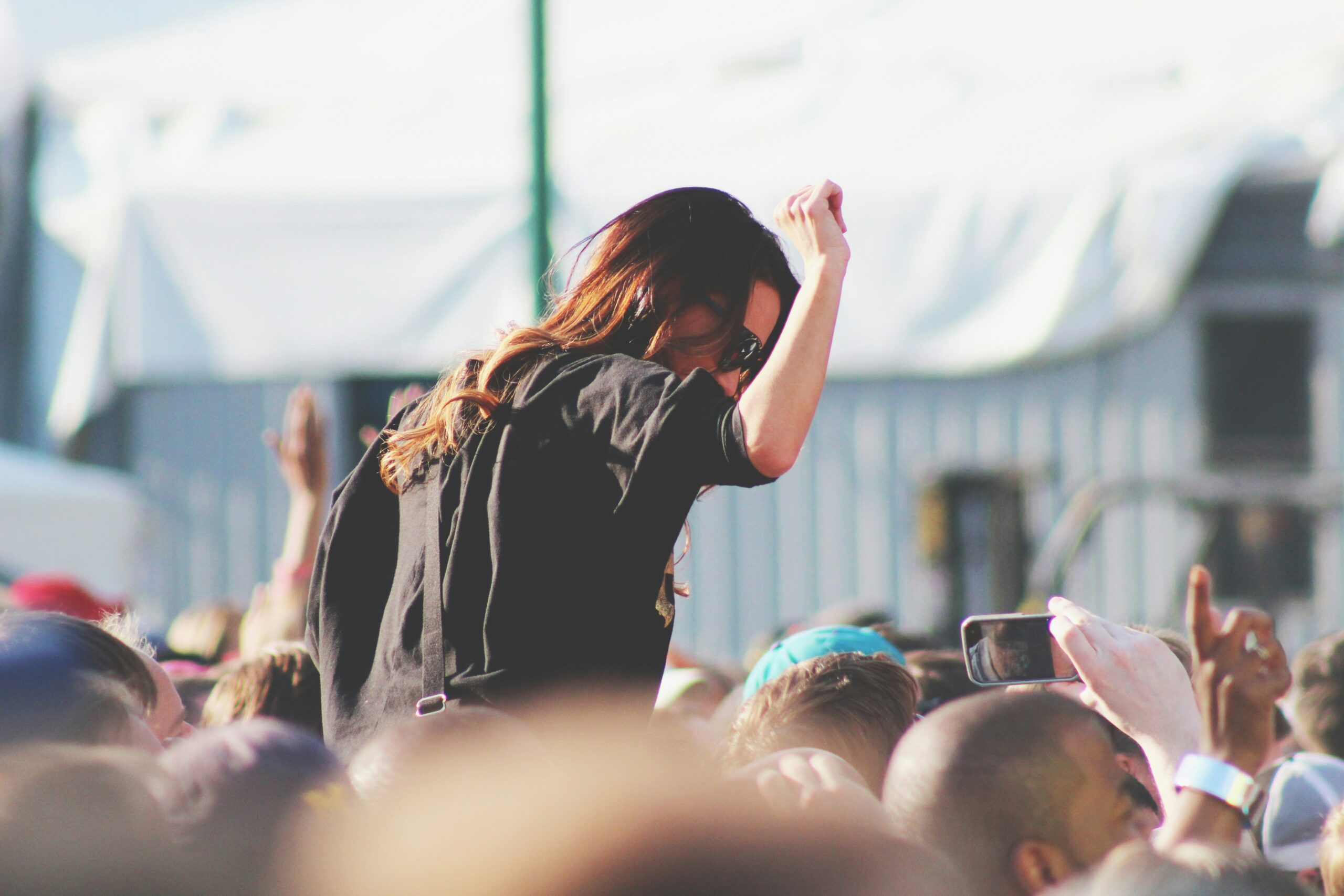 Female attendee dancing at a festival in Louth, enjoying the lively atmosphere with other festival-goers in the background.